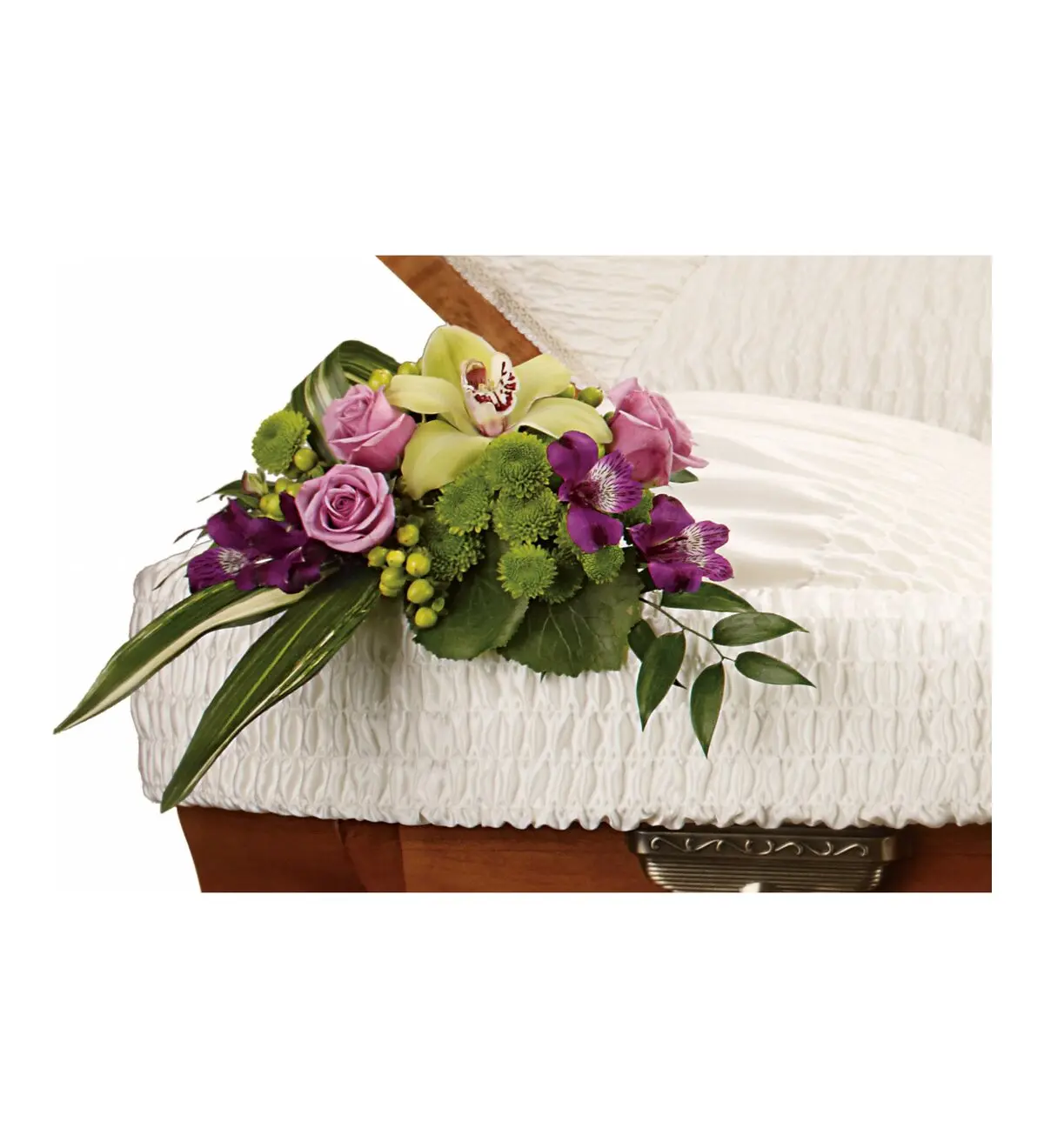 Lavender roses and a green orchid resting on the edge of a casket lining