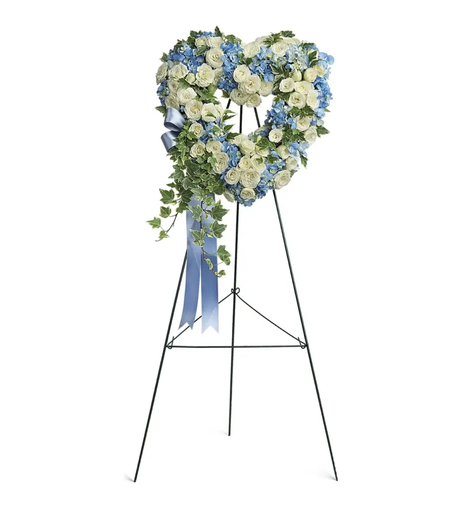 Open heart of white spray roses and blue hydrangea with ribbon on an easel