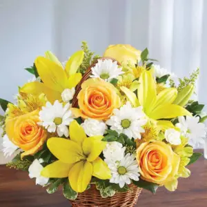 Yellow lilies, roses and white daisies in a small handled wicker basket