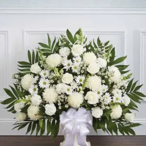 White floor basket of roses, mums and daisies with palm leaves and a white bow