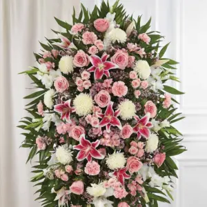 Oval pink and white standing spray of lilies, roses and carnations on an easel