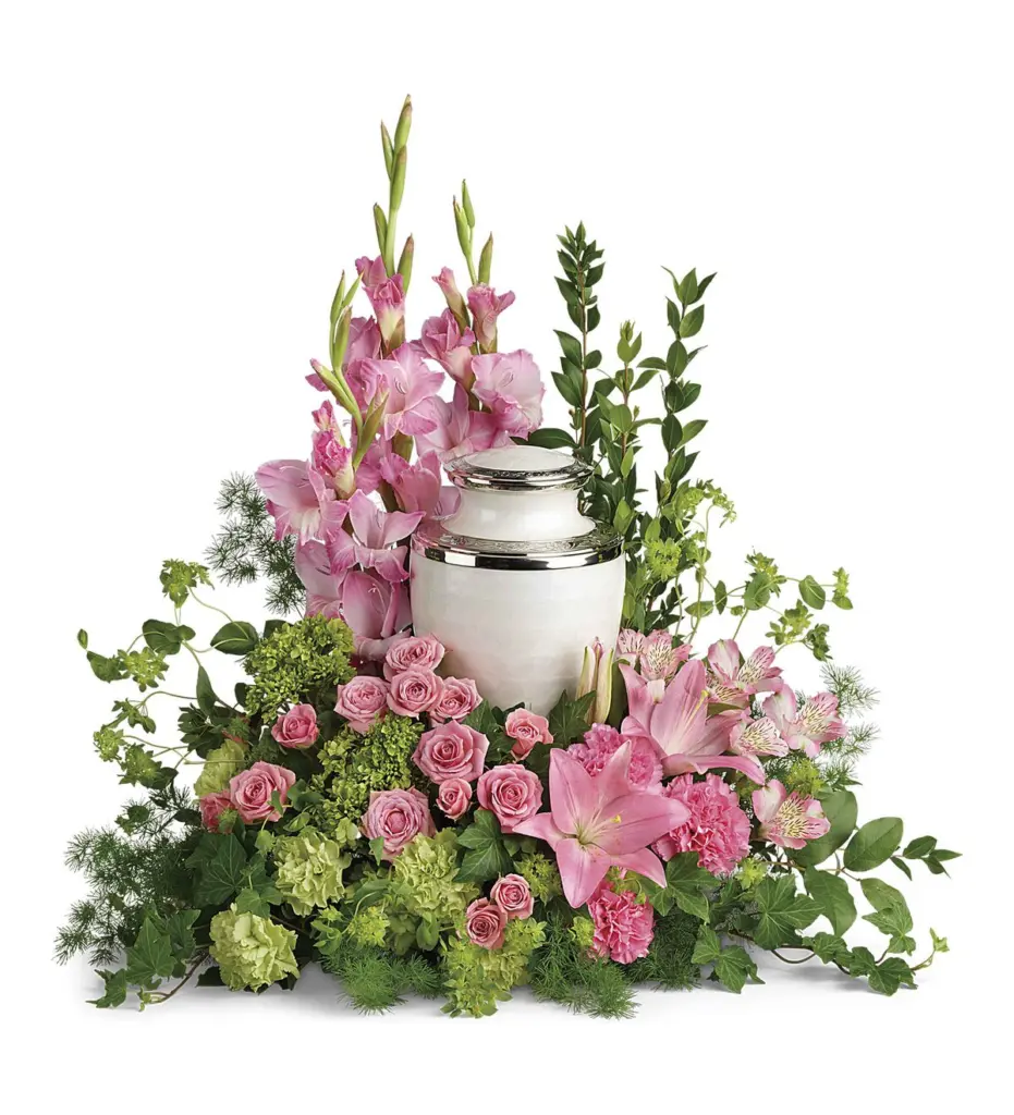 Pink gladiolus, spray roses and lilies around a pearl-white urn with silver trim