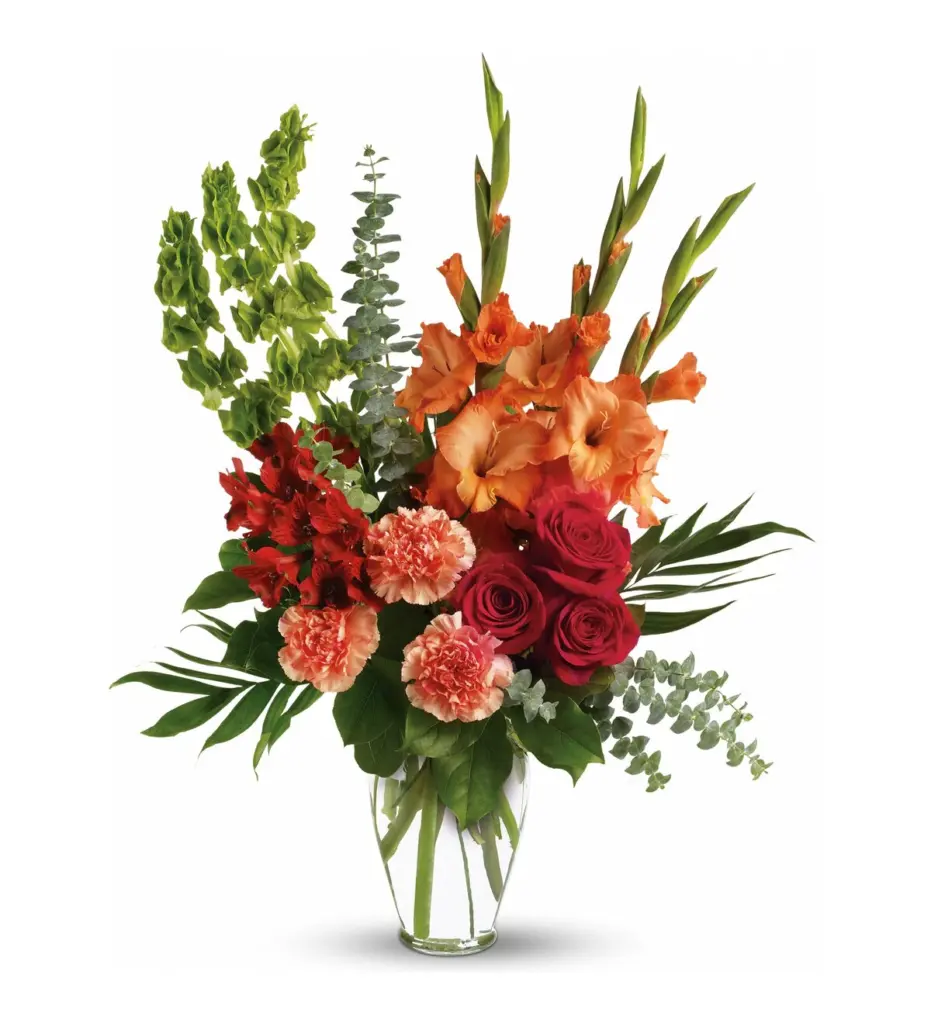 Orange gladiolus, pink roses and red alstroemeria in a clear glass vase
