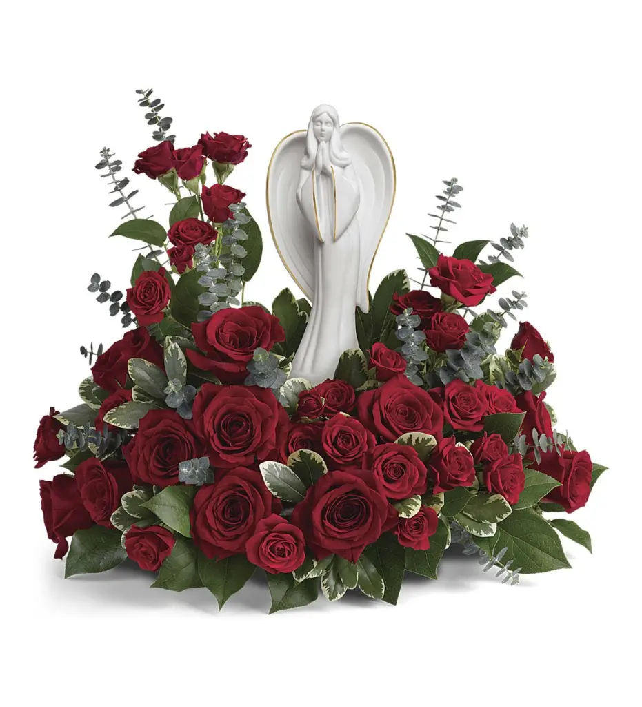 Red roses and eucalyptus surrounding a white porcelain praying angel