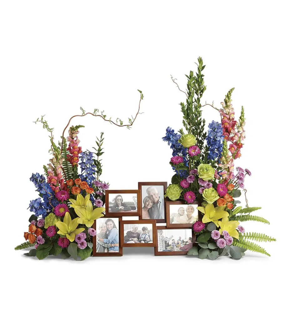 Colorful lilies and delphinium flanking a cluster of seven framed family photos