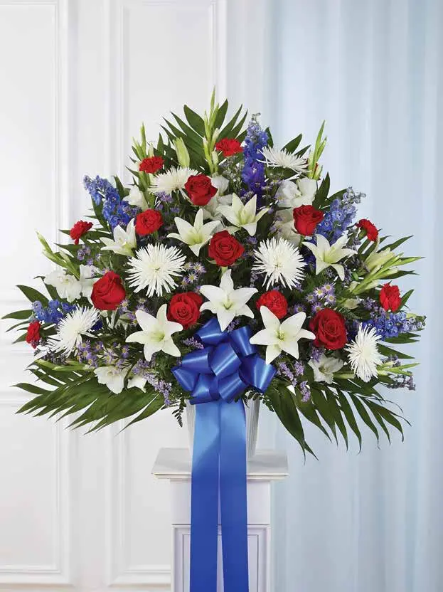 Red, white and blue floor basket of roses, lilies and delphinium on a pedestal