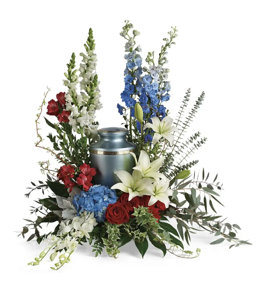 Red, white and blue flowers around a blue memorial urn with a gold band