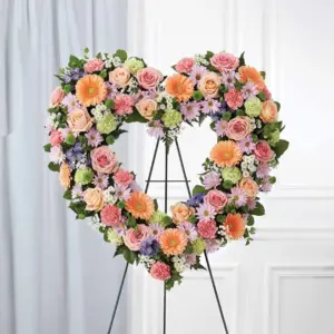 Pastel open heart of gerberas, roses and daisies on a wire easel
