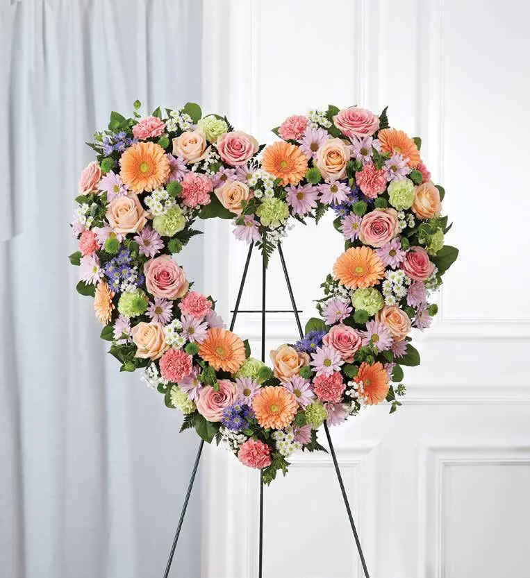Pastel open heart of gerberas, roses and daisies on a wire easel