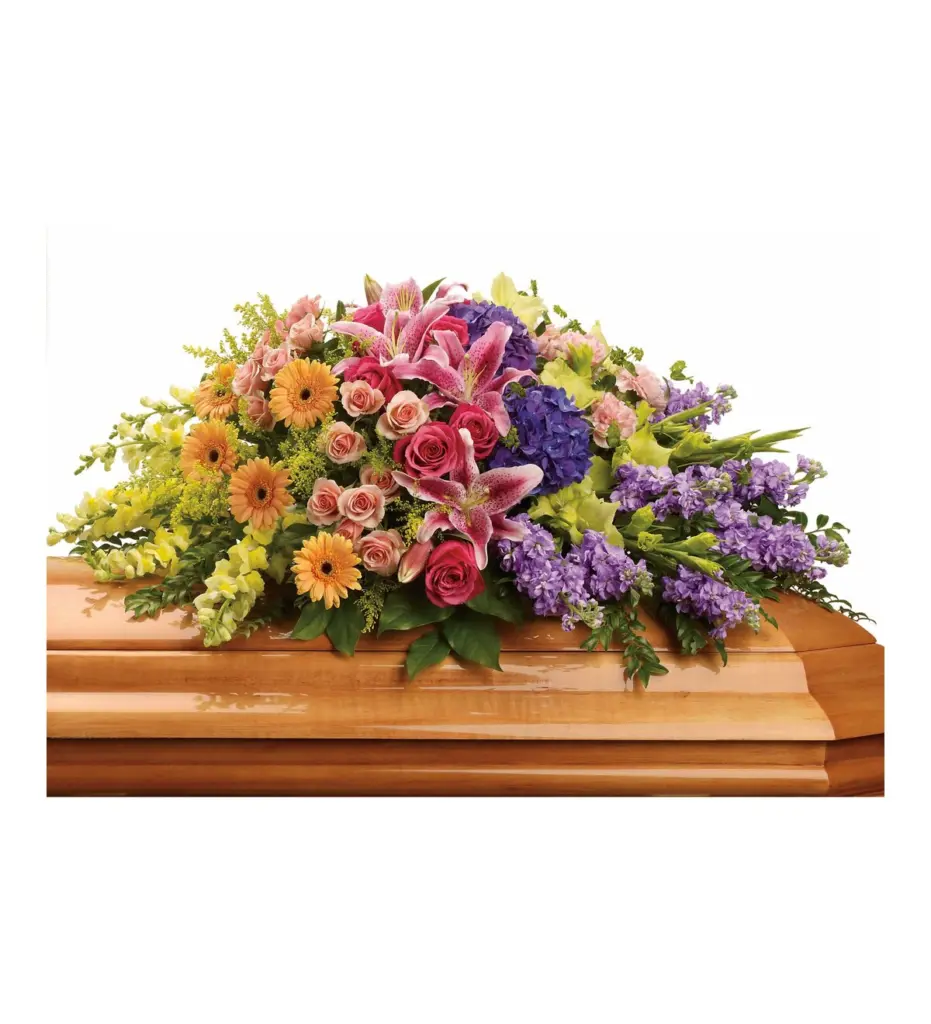 Colorful half casket spray of lilies, roses, hydrangea and stock on a wood casket
