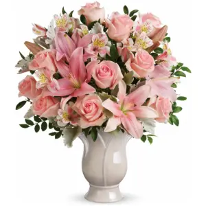 Light pink roses and lilies in a cream ceramic vase