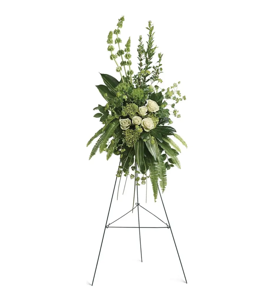 Green and white standing spray with white roses and bells of Ireland on an easel