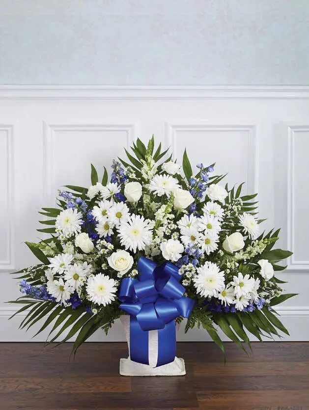 Blue and white floor basket of gerbera daisies and roses with blue bow
