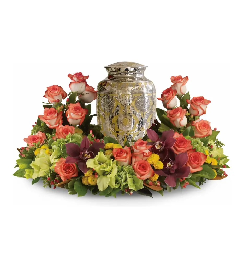 Peach roses, burgundy orchids and green hydrangea circling an engraved metal urn