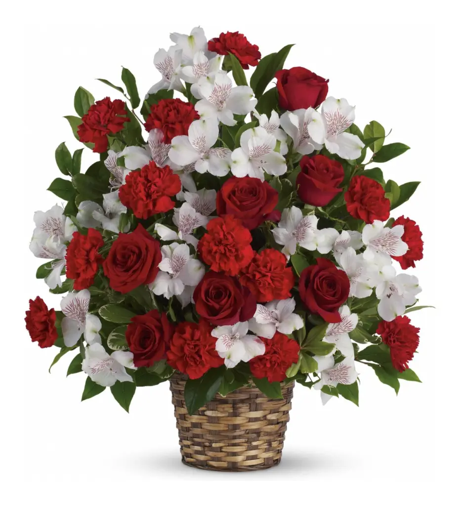 Red roses, red carnations and white alstroemeria in a woven basket