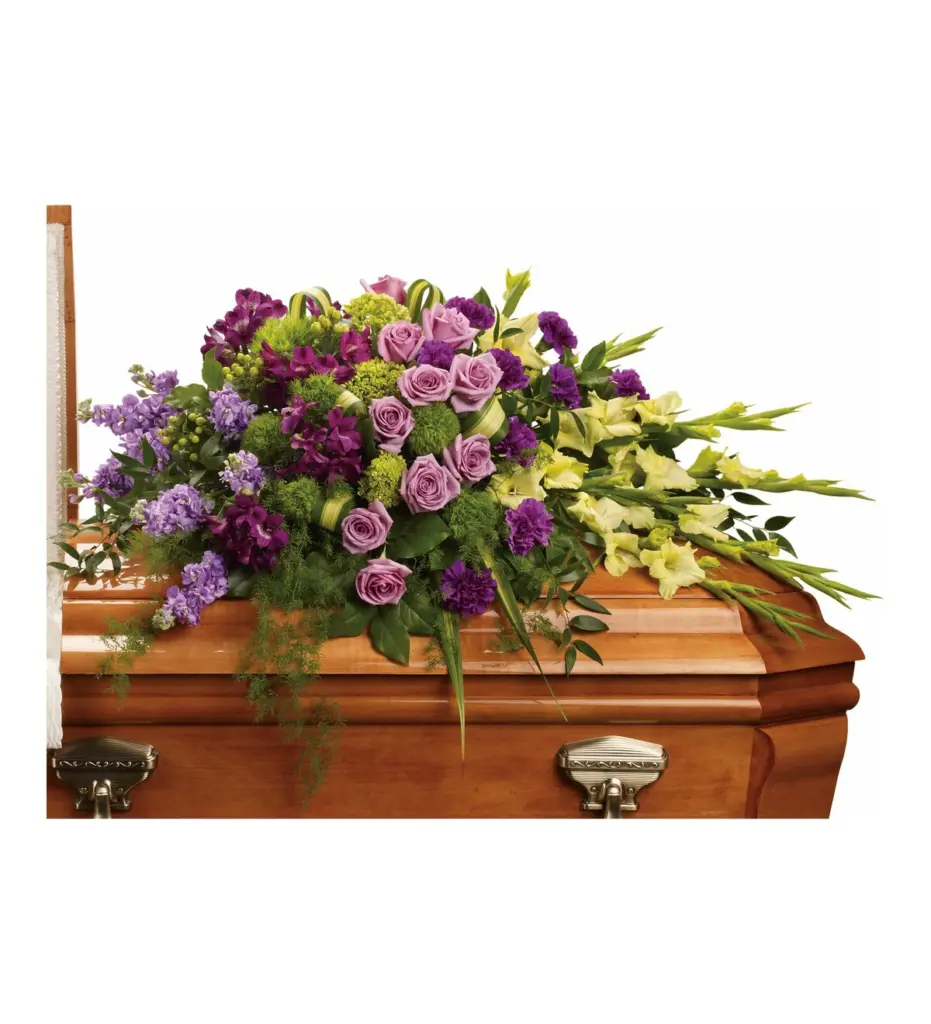 Lavender roses and green gladiolus half casket spray on a wood casket