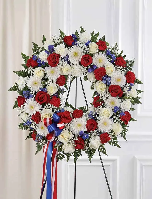 Red, white and blue rose wreath with a striped ribbon on an easel