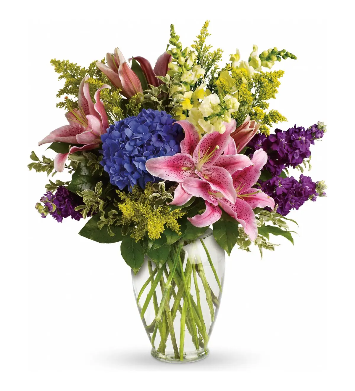 Pink lilies, blue hydrangea and purple stock in a clear glass vase
