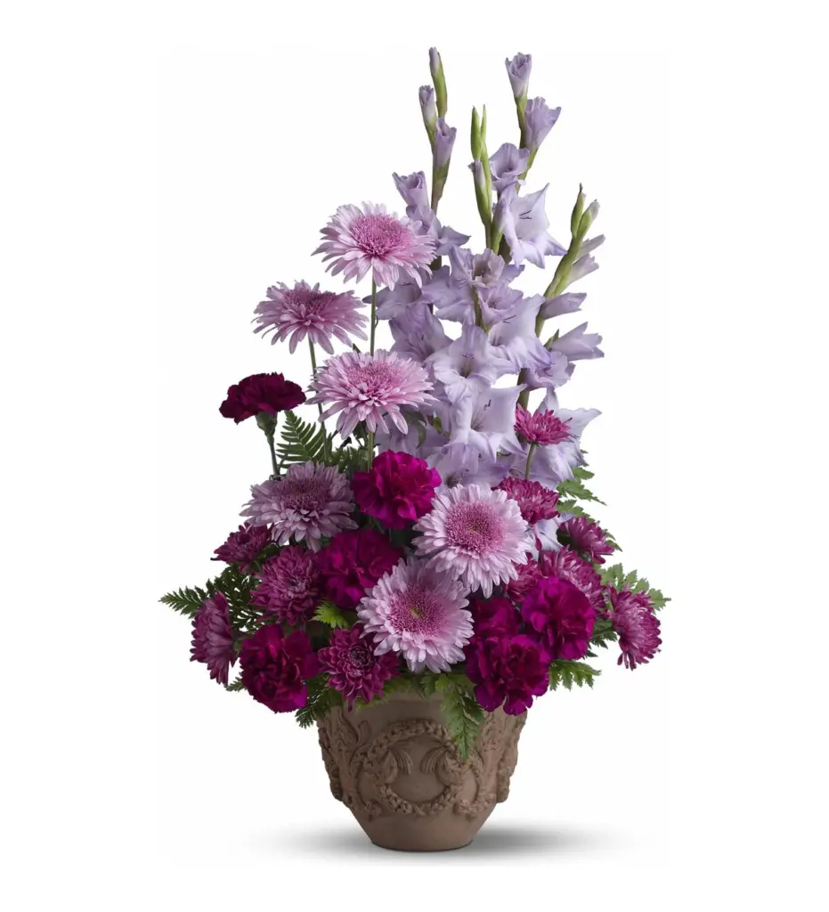 Lavender gladiolus, spider mums and magenta carnations in a carved tan pot