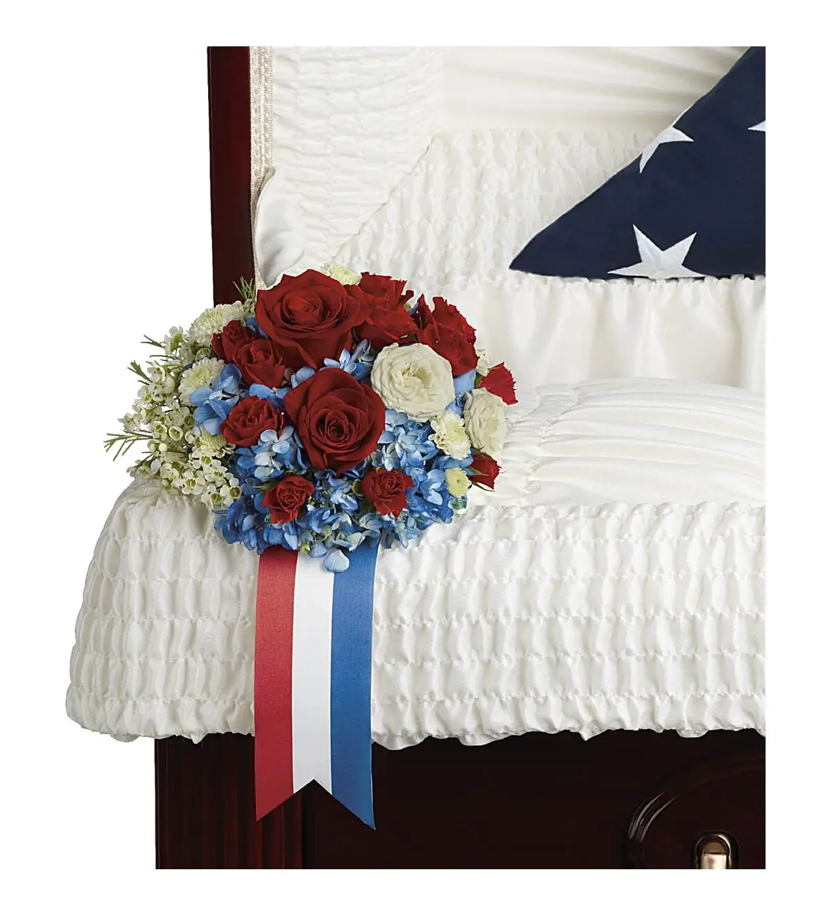 Red roses and blue hydrangea with a red, white and blue ribbon on casket lining