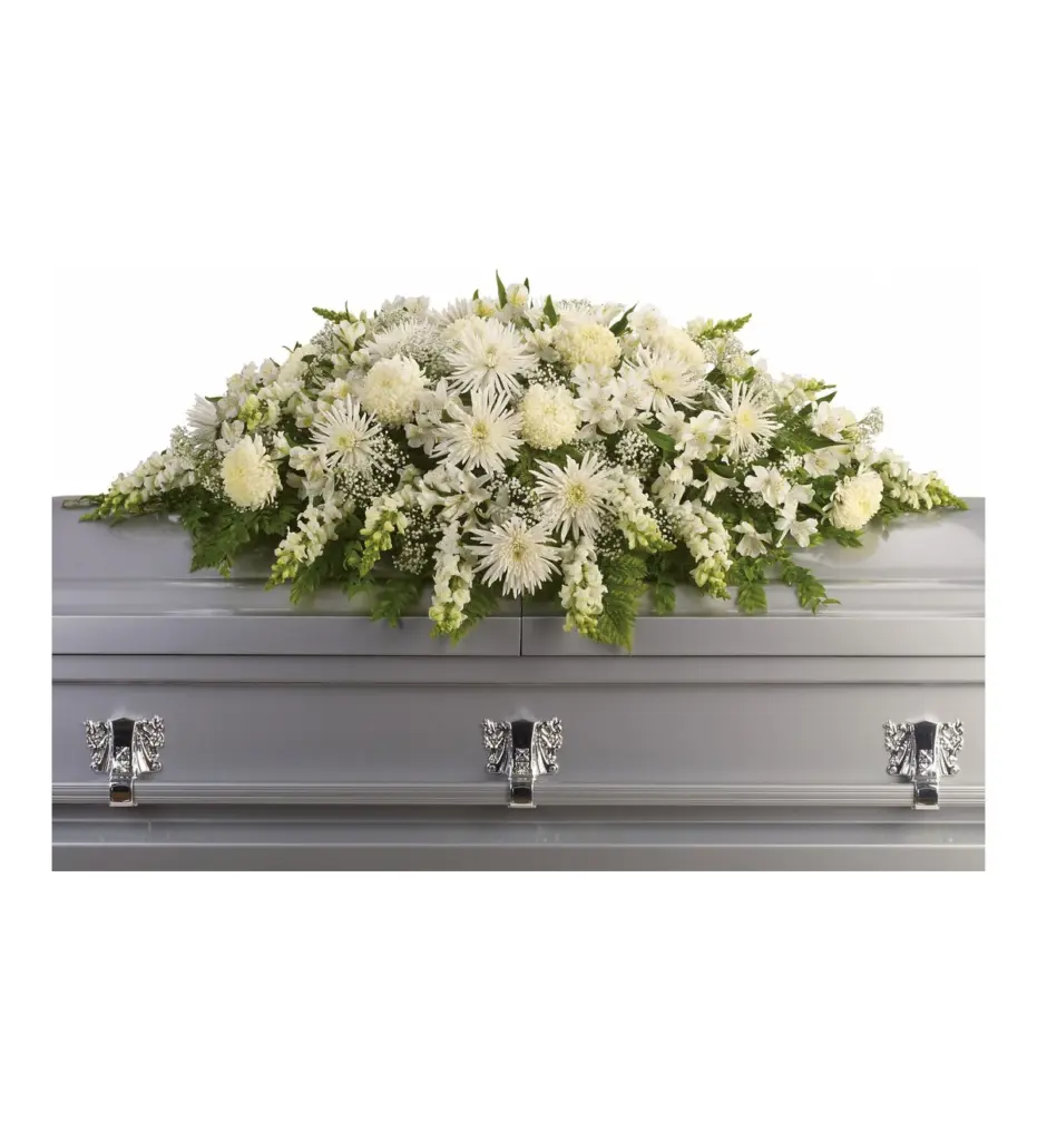 All-white casket spray of mums, snapdragons and baby's breath on silver casket