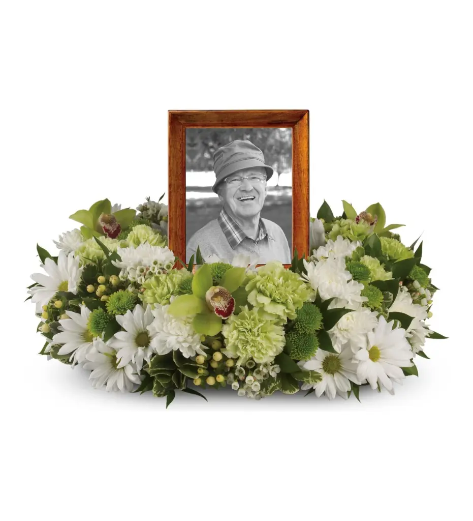 Low ring of white daisies and green flowers around a wood-framed portrait photo