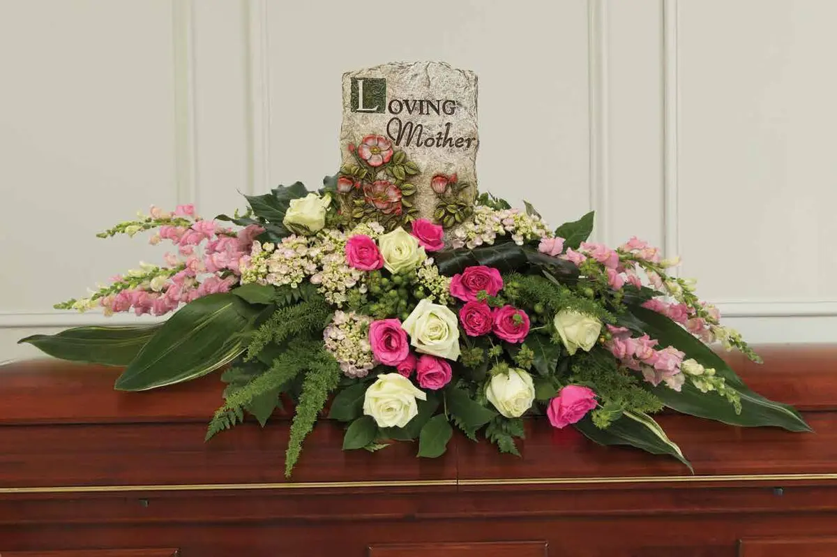 Pink and white rose casket spray with a Loving Mother stone plaque