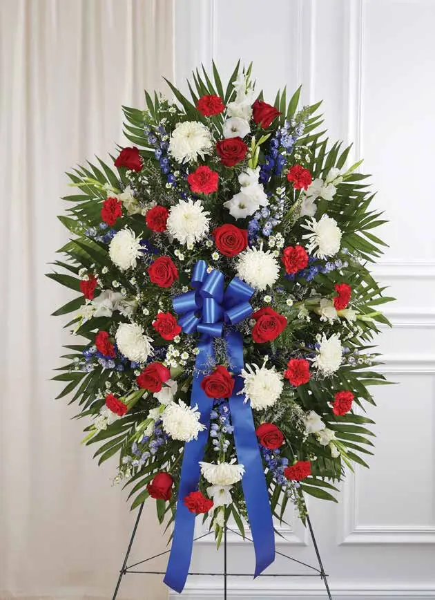 Red, white and blue standing spray with a blue bow on an easel