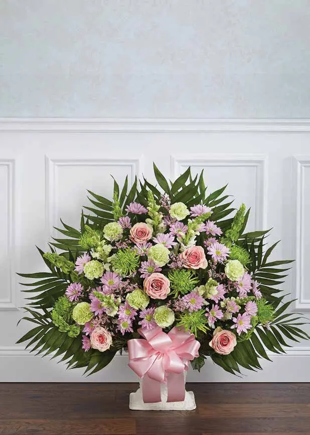Pastel pink and green floor basket of roses and daisies with pink bow