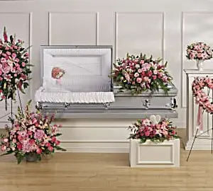 Funeral room with pink casket spray, standing spray, heart and matching arrangements