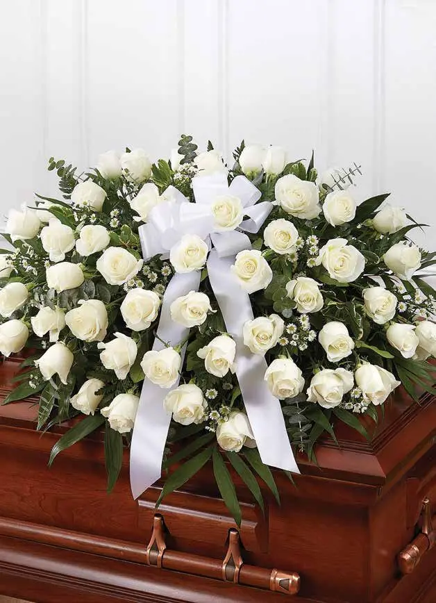 Half casket spray of white roses with a white satin bow
