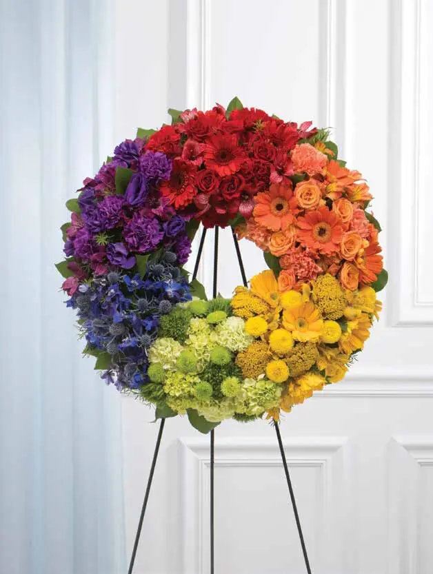 Rainbow-colored standing wreath of flowers in red, orange, yellow, green, blue and purple