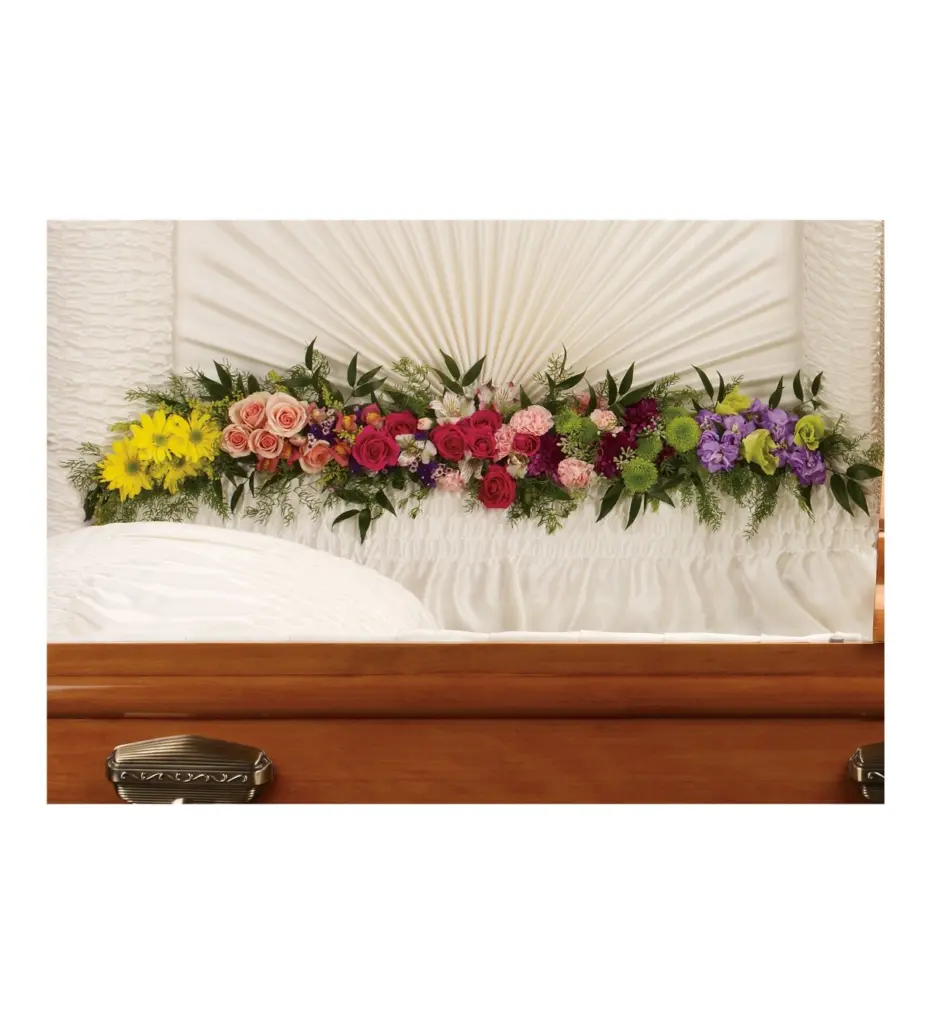 Rainbow garland of daisies, roses and mums inside an open wood casket lid