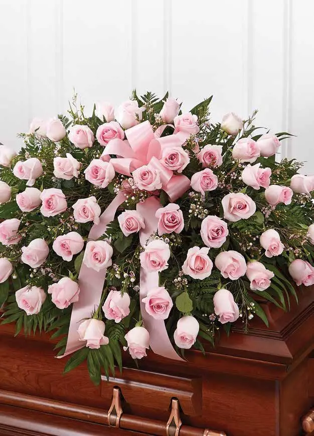 Half casket spray of pink roses with a pink satin bow