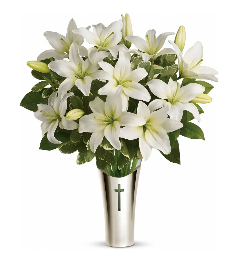 White lilies in a silver keepsake vase with a cross emblem