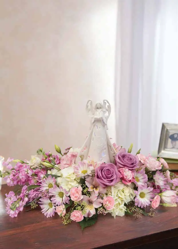 Lavender roses and pink daisies around a white angel figurine