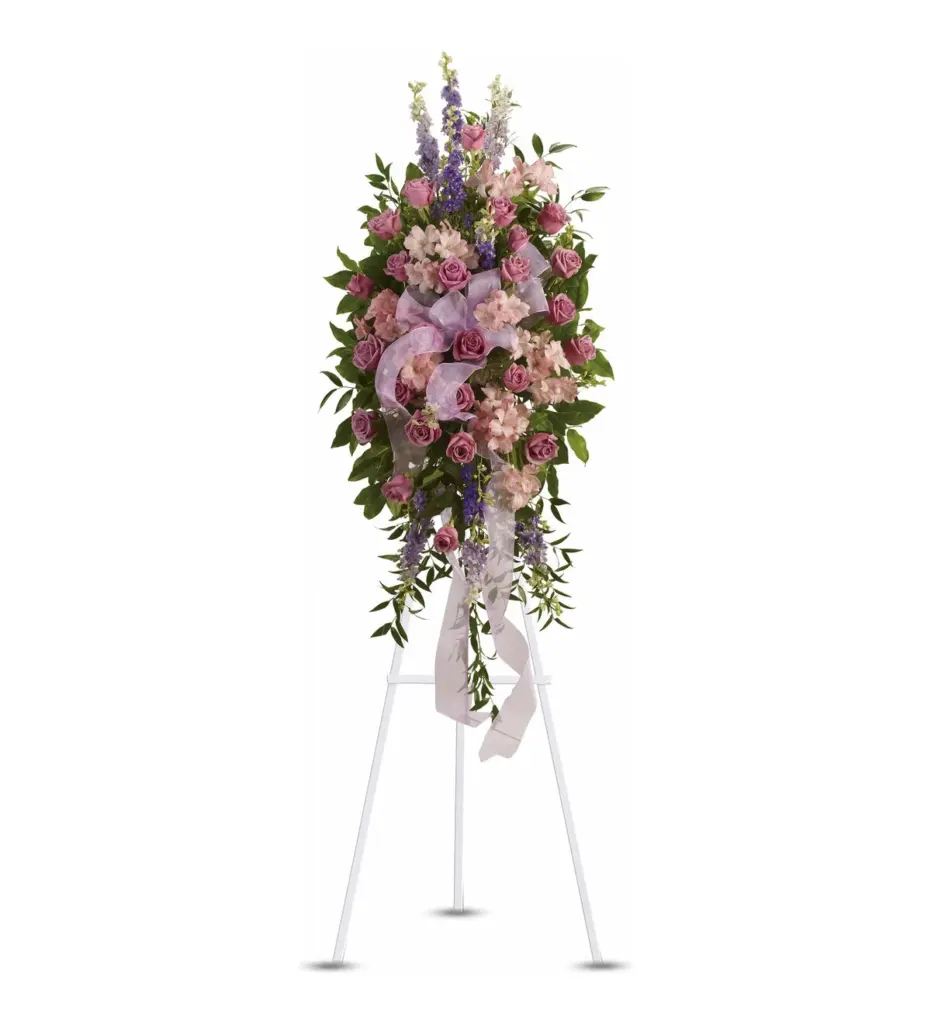 Pink rose and alstroemeria standing spray with sheer lavender ribbon on white easel