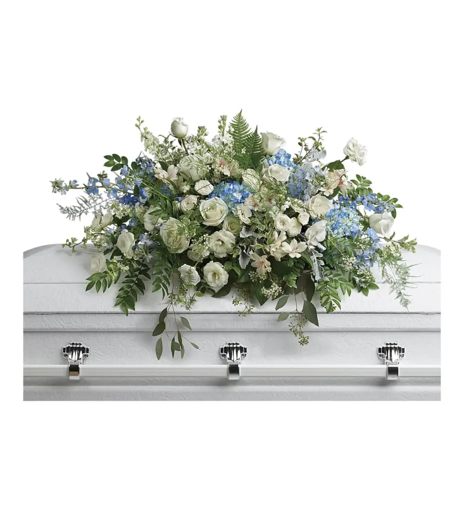 Blue and white casket spray of roses and hydrangea on a white casket