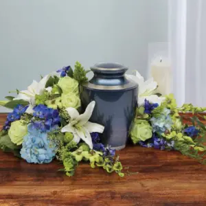 Blue urn surrounded by white lilies, green roses and blue hydrangea with candles