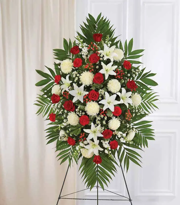 Red roses and white lilies in a diamond-shaped standing spray on an easel