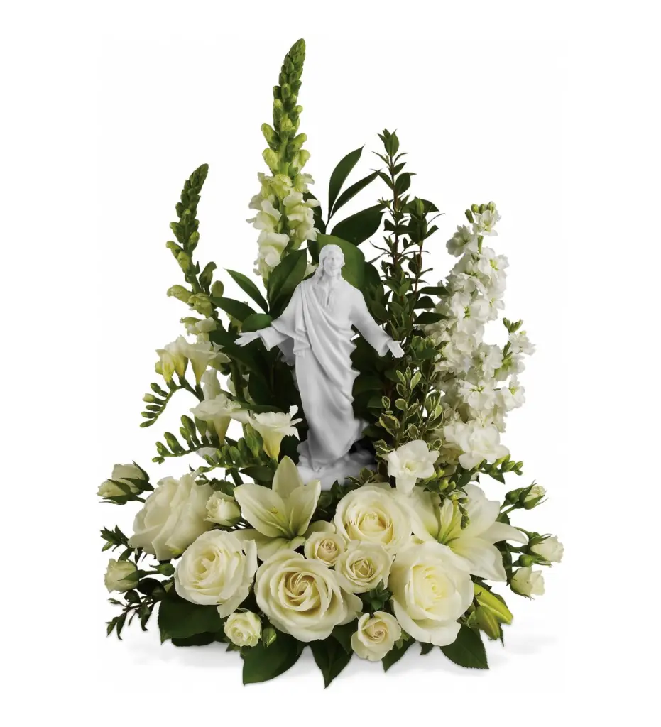 White Christ statue with arms open surrounded by white roses and lilies