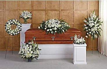 Funeral room with white casket spray, wreath, standing spray and matching arrangements