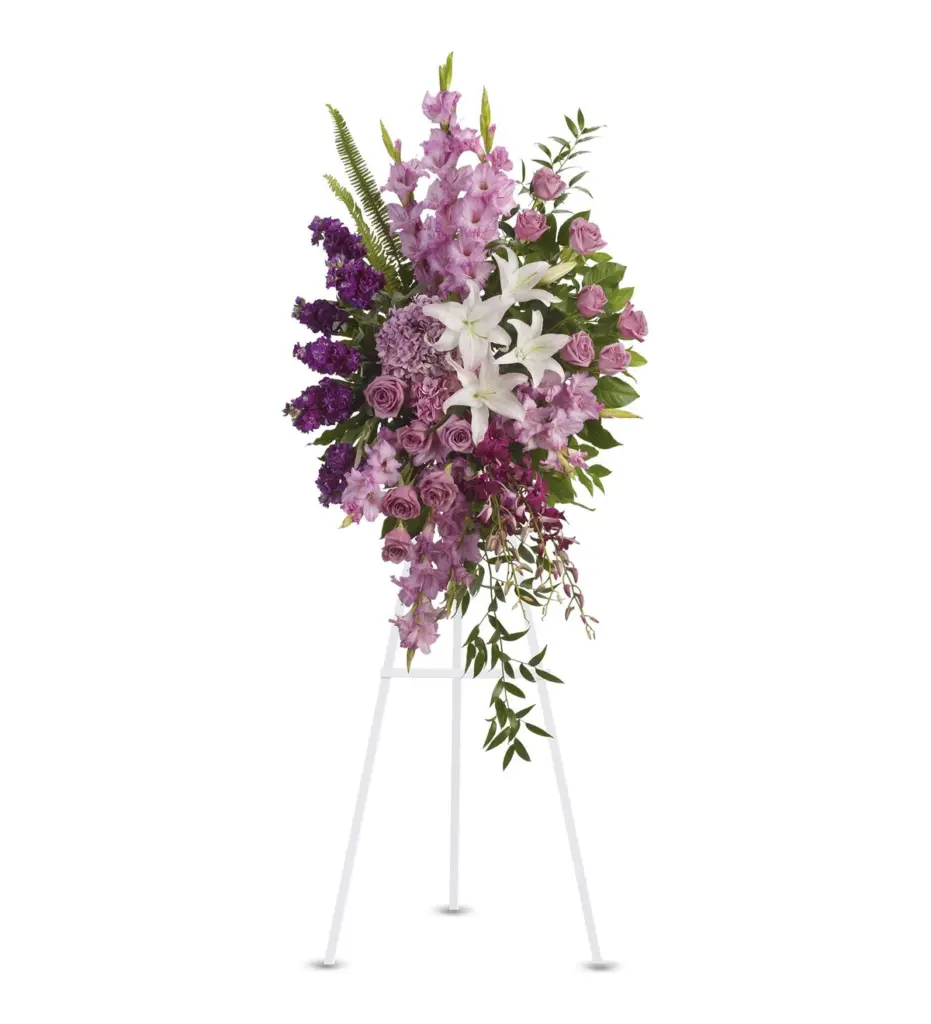 Lavender and purple standing spray with white lilies, roses and orchids on white easel